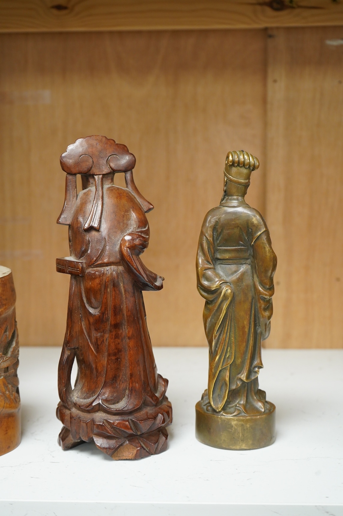 A bronzed Chinese figure of Qianlong, a carved bamboo brush pot and a hardwood figure, largest 20cm high